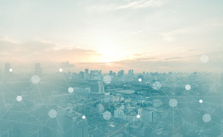 City skyline at sunset with an abstract network overlay featuring connected dots and lines.